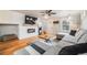 Modern living room with a TV, sleek fireplace, large gray sectional, and hardwood floors at 1495 Hummingbird Cir, Brighton, CO 80601