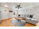 Bright living room with a large gray sectional sofa, hardwood floors, and natural light at 1495 Hummingbird Cir, Brighton, CO 80601