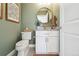 Stylish powder room featuring sage green walls, decorative fixtures, and modern vanity at 2480 Quitman St, Denver, CO 80212