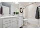 Bright bathroom features modern vanity, ample storage, and a tub with a shower featuring subway tile at 2480 Quitman St, Denver, CO 80212