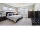 Comfortable bedroom with a dark wood bed frame, carpeted floors, and natural light from multiple windows at 2480 Quitman St, Denver, CO 80212