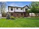 Charming two-story home with brick and white siding, manicured lawn, and inviting curb appeal at 2480 Quitman St, Denver, CO 80212