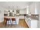 Spacious kitchen featuring a central island with seating, granite counters, and hardwood floors at 2480 Quitman St, Denver, CO 80212