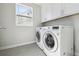 Well-lit laundry room with modern washer and dryer units and ample storage space at 2480 Quitman St, Denver, CO 80212