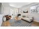 Bright living room featuring a comfortable sofa, stylish rug, and abundant natural light at 2480 Quitman St, Denver, CO 80212