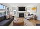 Cozy living room featuring a stone fireplace, large windows, comfortable seating, and hardwood flooring at 2480 Quitman St, Denver, CO 80212