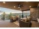 Outdoor deck with wicker furniture, stone accent wall, wood ceiling and serene views at 8103 Raphael Ln, Littleton, CO 80125
