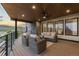 Inviting outdoor deck with wicker furniture, a stone accent wall, and scenic views at 8103 Raphael Ln, Littleton, CO 80125