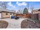 Private backyard boasts a large stone patio, wood fence, and space for outdoor entertaining at 925 Steele St, Denver, CO 80206