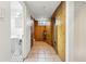 Basement hallway features tile flooring, wood paneling, doors, and access to a small bathroom with pedestal sink at 925 Steele St, Denver, CO 80206