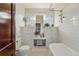 Bright bathroom with white subway tile, a soaking tub, classic fixtures, and built-in storage cabinets at 925 Steele St, Denver, CO 80206