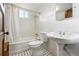 Bright bathroom features white tile, black and white tile floor, shower-tub combo, and pedestal sink at 925 Steele St, Denver, CO 80206