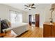 Sunlit bedroom features hardwood floors, a ceiling fan, a double-door closet, and windows with sheer curtains at 925 Steele St, Denver, CO 80206