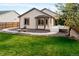 Manicured backyard featuring a lush lawn, stone landscaping, and a charming patio at 21069 Woodside Ln, Parker, CO 80138