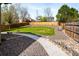 Serene backyard with stone landscaping, green lawn, and mature trees at 21069 Woodside Ln, Parker, CO 80138