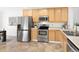 Efficient kitchen layout with stainless steel appliances and light wood cabinets at 21069 Woodside Ln, Parker, CO 80138