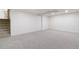 Finished basement with gray carpet, white walls, and stairs leading up at 6581 E Heritage Pl, Englewood, CO 80111