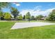 Outdoor basketball court on a lush green lawn with mature trees and benches at 6581 E Heritage Pl, Englewood, CO 80111