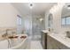 Bathroom featuring a soaking tub, glass shower, double vanity, and neutral tiling at 6581 E Heritage Pl, Englewood, CO 80111