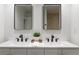 Modern bathroom featuring double sinks, stylish mirrors, and sleek black fixtures at 6581 E Heritage Pl, Englewood, CO 80111