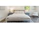 Bedroom with a light gray bed frame, white bedding, bedside tables, and a sunlit window at 6581 E Heritage Pl, Englewood, CO 80111