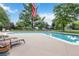 Community pool with lounge chairs, an American flag, and mature green trees at 6581 E Heritage Pl, Englewood, CO 80111
