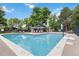 Large community pool surrounded by mature trees, lounge chairs, and shade structures at 6581 E Heritage Pl, Englewood, CO 80111