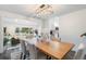 Bright dining room showcasing hardwood table, modern chandelier, and seamless flow to kitchen and living areas at 6581 E Heritage Pl, Englewood, CO 80111
