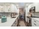 Modern kitchen with white cabinets, stainless steel appliances, and sleek countertops at 6581 E Heritage Pl, Englewood, CO 80111