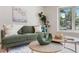 Cozy living room featuring green sofa, hardwood floors, and stylish decor at 6581 E Heritage Pl, Englewood, CO 80111