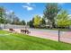 Outdoor tennis court with benches in a landscaped community setting at 6581 E Heritage Pl, Englewood, CO 80111