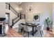 A beautifully staged dining room boasts modern lighting, a sleek table setting, and a view of the staircase at 19481 E Milan Cir, Aurora, CO 80013