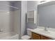 Cozy bathroom features a tub with white tiled walls, cabinet, and large mirror at 11149 Gaylord St, Northglenn, CO 80233