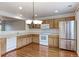 Kitchen with stainless steel refrigerator, white appliances, and wood cabinets at 11149 Gaylord St, Northglenn, CO 80233