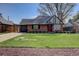 Charming brick home featuring a well-manicured lawn and a pop of color from the red front door at 782 Holly St, Denver, CO 80220