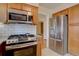 Well-equipped kitchen features stainless steel appliances, light wood cabinets, and white tile backsplash at 782 Holly St, Denver, CO 80220