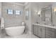 Bathroom featuring a sleek white soaking tub, marble walls and floors, and a modern vanity at 15191 Dinosaur Ridge Rd, Morrison, CO 80465