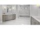 Bright bathroom featuring dual vanities, marble flooring, and a glass enclosed shower at 15191 Dinosaur Ridge Rd, Morrison, CO 80465