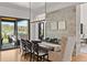 Elegant dining room features a rustic wood table, statement lighting, and scenic views through large windows at 15191 Dinosaur Ridge Rd, Morrison, CO 80465