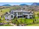 Beautiful two story home with white siding, stone accents, black trim and professionally landscaped yard at 15191 Dinosaur Ridge Rd, Morrison, CO 80465