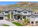 Elegant home exterior with a three-car garage and stone accents, complemented by mature landscaping at 15191 Dinosaur Ridge Rd, Morrison, CO 80465