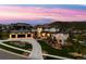 Aerial view of luxury home at twilight featuring professional landscaping and a large driveway at 15191 Dinosaur Ridge Rd, Morrison, CO 80465