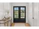 Inviting foyer with double glass doors offering scenic views and a rustic console table at 15191 Dinosaur Ridge Rd, Morrison, CO 80465