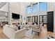 Elegant living room featuring a modern fireplace, soaring ceilings, and abundant natural light at 15191 Dinosaur Ridge Rd, Morrison, CO 80465