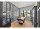 Bright home office features stylish wood paneling, a built-in desk, and scenic outdoor views at 15191 Dinosaur Ridge Rd, Morrison, CO 80465