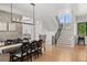 Open space shows an elegant dining area with rustic table and staircase with iron railings and wood treads at 15191 Dinosaur Ridge Rd, Morrison, CO 80465
