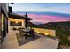 Outdoor dining area with built-in barbecue and beautiful views of the Colorado landscape at sunset at 15191 Dinosaur Ridge Rd, Morrison, CO 80465