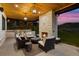 Outdoor living space featuring a stone fireplace, built-in grill, wooden ceiling, and comfortable seating at sunset at 15191 Dinosaur Ridge Rd, Morrison, CO 80465