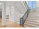 Bright foyer showcases a modern staircase with iron railings and wood treads, complemented by stylish decor at 15191 Dinosaur Ridge Rd, Morrison, CO 80465