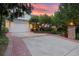 Long driveway leading to an attached garage, surrounded by beautiful landscaping and a vibrant sunset at 5530 E 6Th Ave Pkwy, Denver, CO 80220